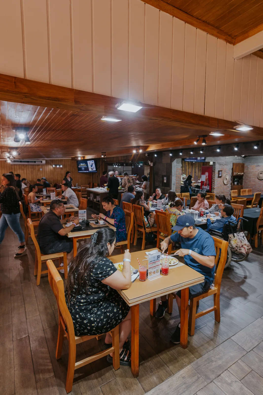 Comensales disfrutando en el salón de madera del buffet