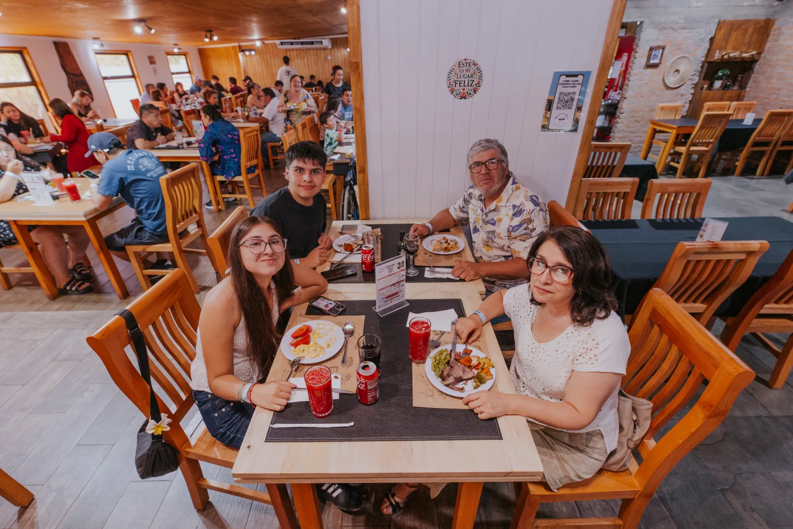Familia de cuatro disfrutando del buffet con bebidas en su mesa