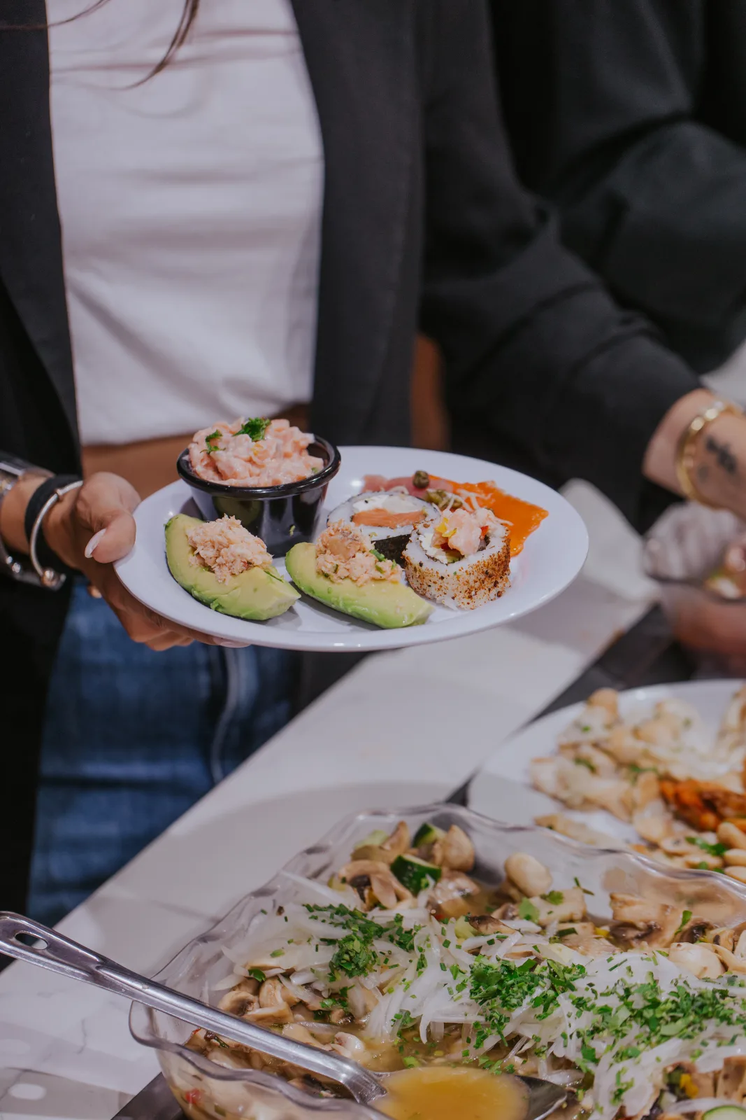 Plato con paltas rellenas, sushi y ceviche junto al buffet de mariscos