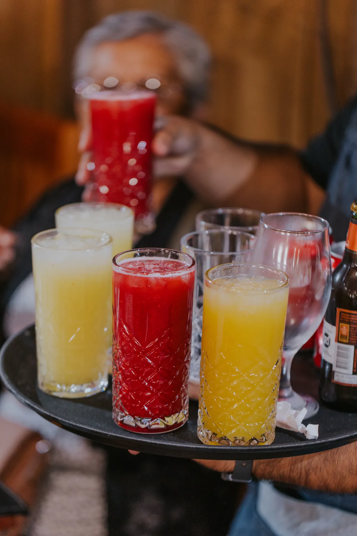 Bandeja con coloridos jugos naturales en vasos labrados
