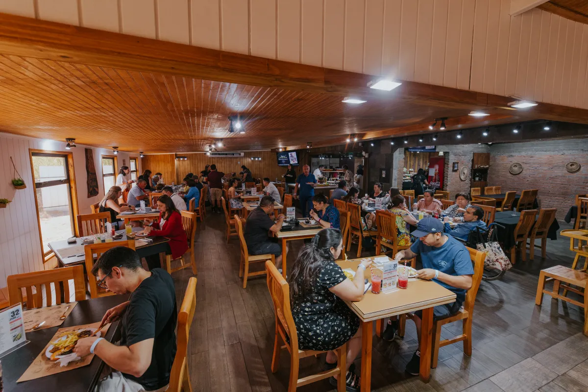 Salón cálido de madera con familias compartiendo almuerzo